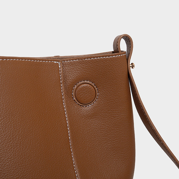 Große, formstabile trapezförmige Tote-Bag aus braunem Lederimitat mit genarbter Oberfläche, zwei Tragegriffen und seitlichen Bindebändern, Detail