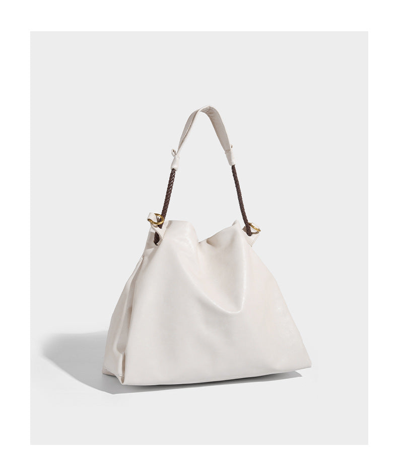 Cream slouchy drawstring bucket bag with braided cord, beaded tassel charm, and gold-tone ring hardware, detail view 10