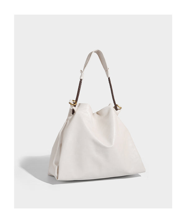 Cream slouchy drawstring bucket bag with braided cord, beaded tassel charm, and gold-tone ring hardware, detail view 10