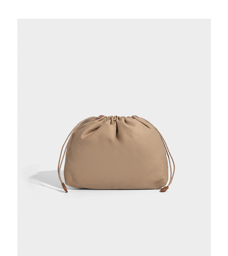 Structured woven herringbone tote bag with braided double shoulder handles in tan brown, shown with matching drawstring