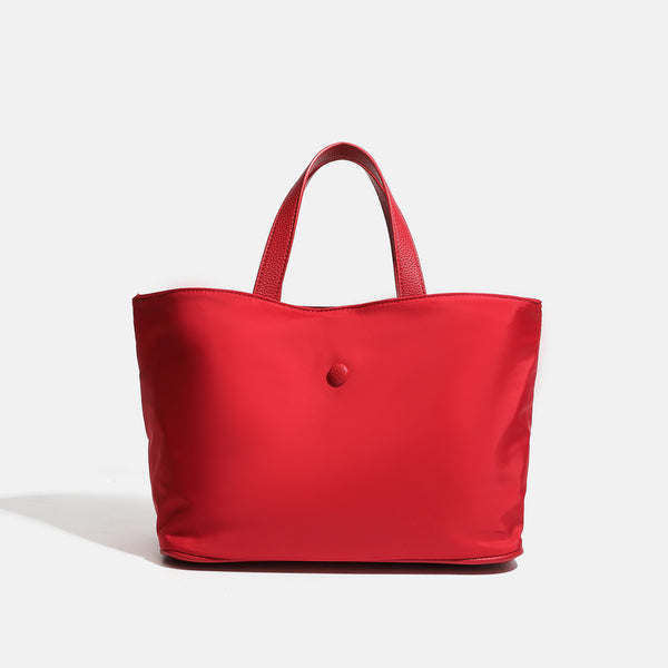 Structured lightweight nylon tote bag with textured double top handles and snap-button front detail, detail view 7