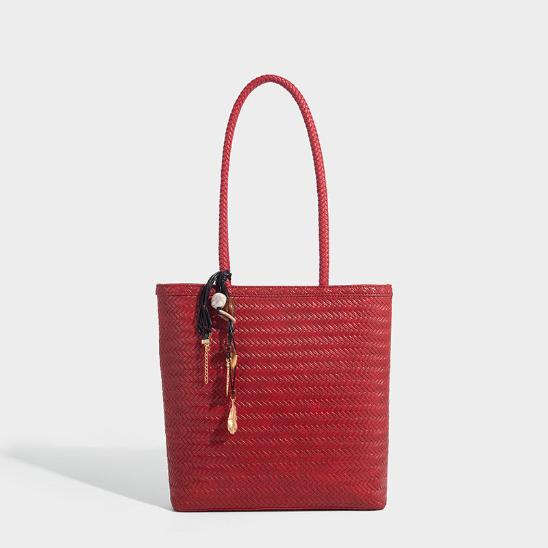 Structured woven herringbone tote bag with braided double shoulder handles in tan brown, shown with matching drawstring