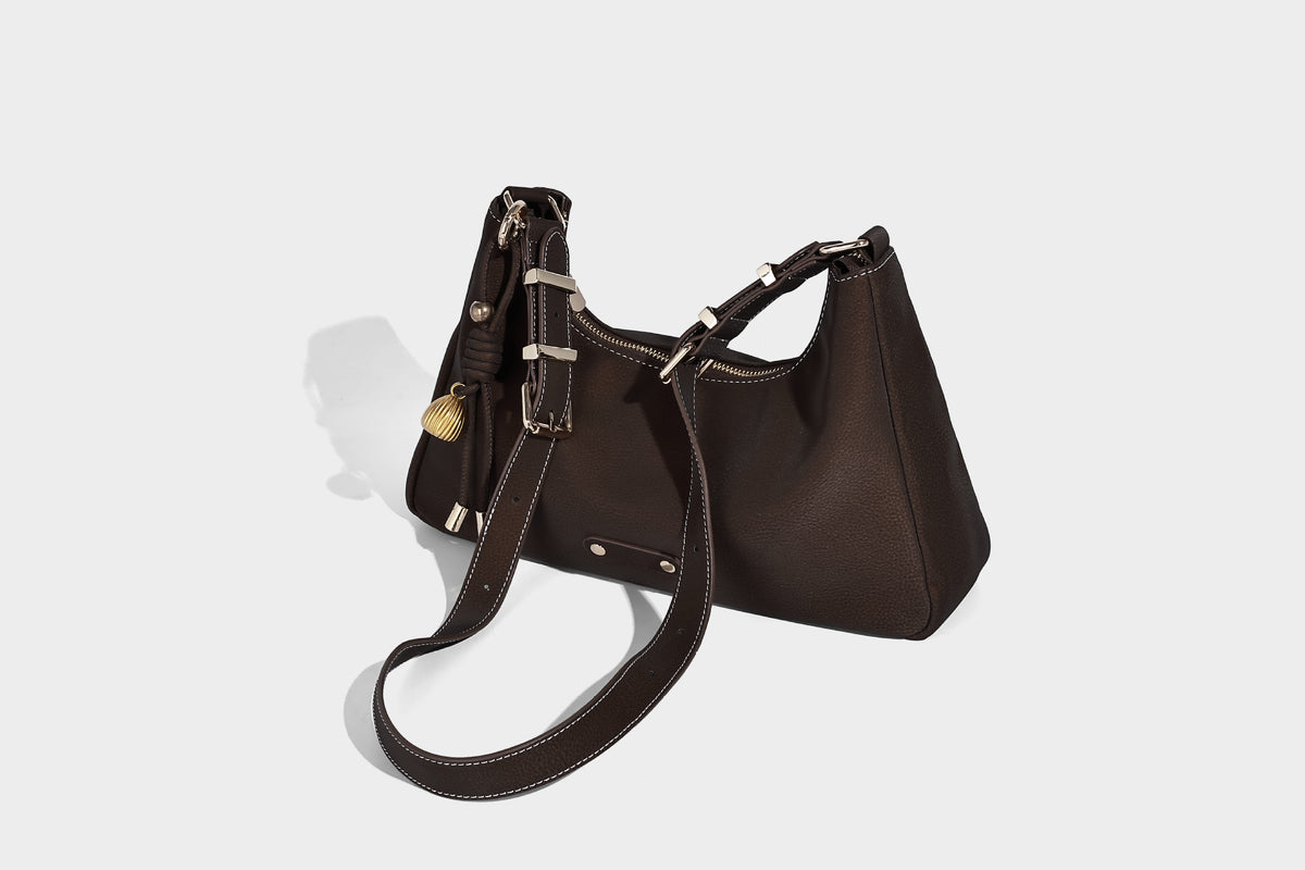 Crescent hobo shoulder bag in pebbled leather-look finish with top zipper, adjustable strap, gold-tone ring hardware, and