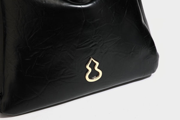 Glänzende, geknautschte Henkeltasche in Lederoptik mit goldfarbenen Emblem-Details und abnehmbarem Schulterriemen, Detailansicht 33