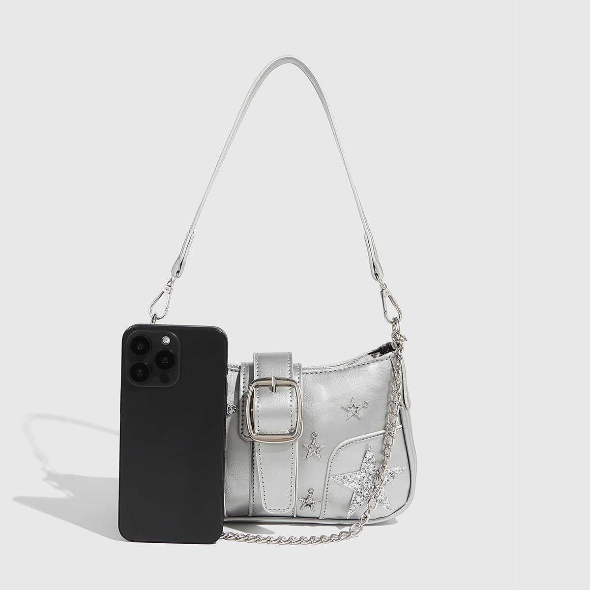 Compact metallic silver shoulder bag with glitter star appliqués, rhinestone star charms, front belt buckle strap, chunky
