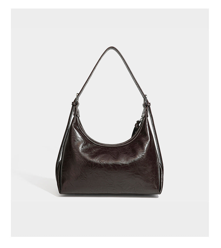 Slouchy hobo shoulder bag in glossy crinkled leather-look finish with zip-top closure and silver-tone ring hardware, detail