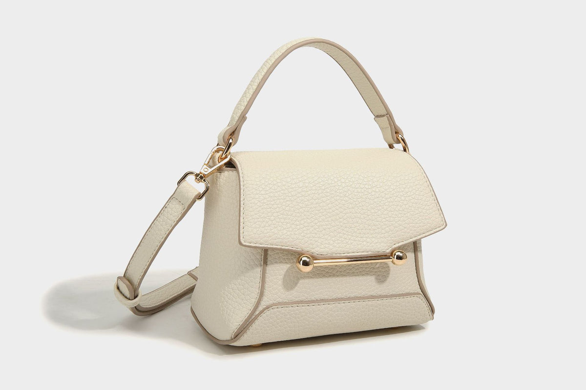 Small structured pebbled flap mini satchel with gold-tone bar hardware, short top handle, and detachable crossbody strap