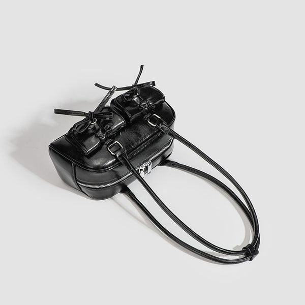 Kompakte Schultertasche aus glänzender Lederoptik mit vorderen Taschen und Schleifen-Kordelzug, Reißverschluss oben, zwei Tragegriffen und, Detailansicht