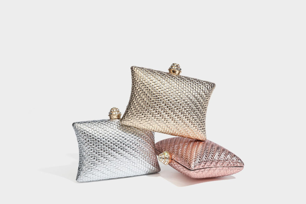 Small structured rectangular metallic woven-texture clutch bag with jeweled knob clasp and gold-tone chain strap, detail view