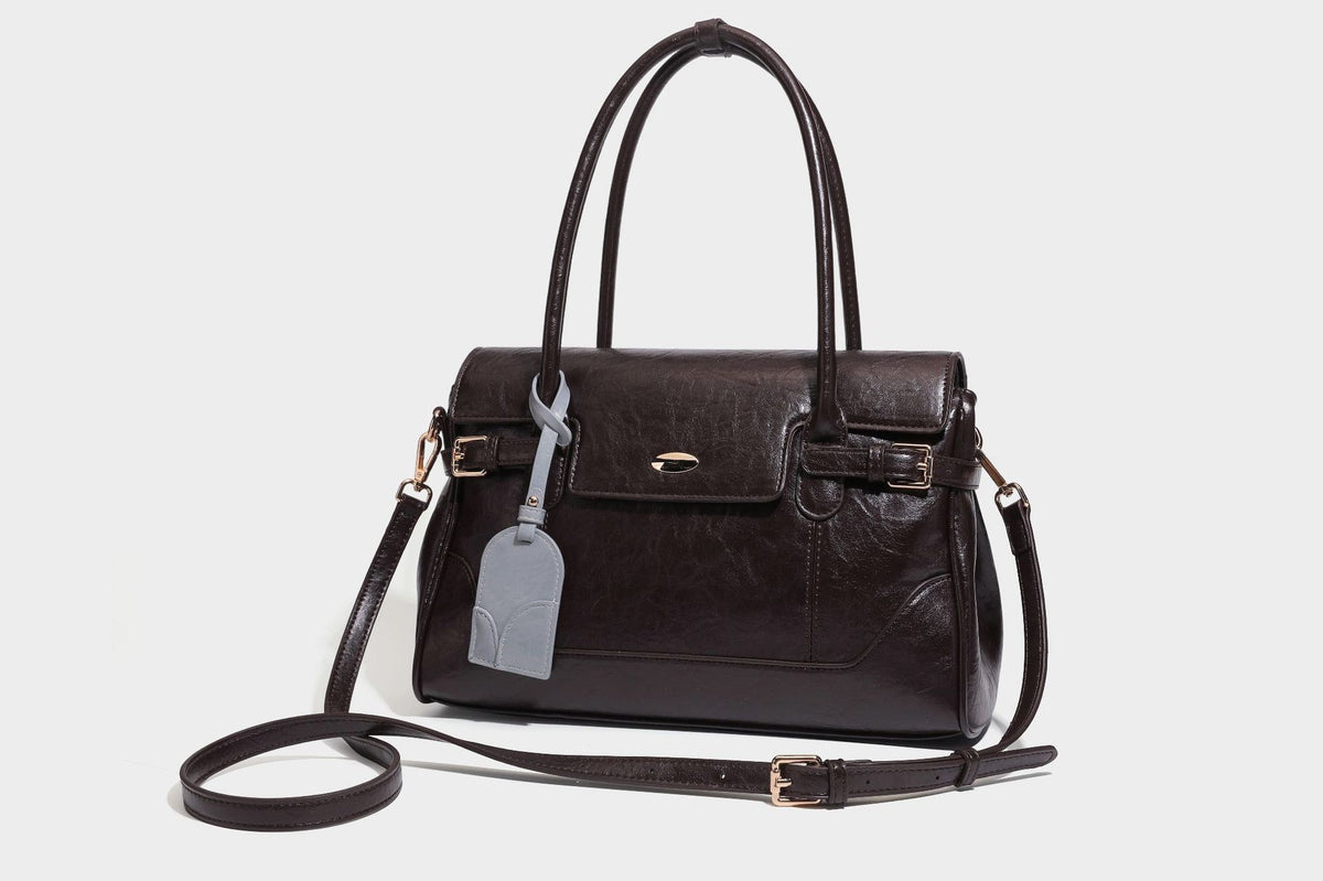 Structured glossy leather-look satchel bag with flap closure, gold-tone buckle accents, double top handles, detachable