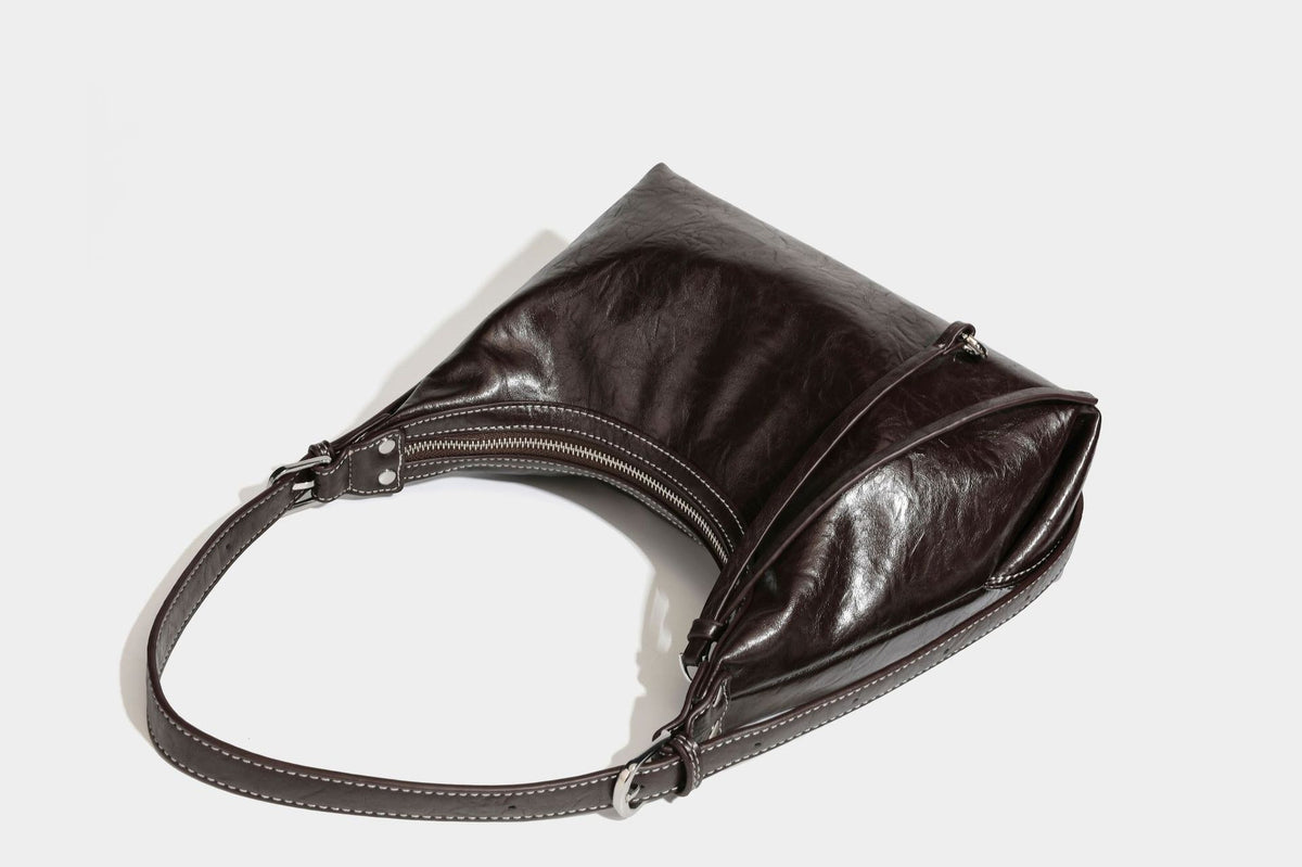 Slouchy hobo shoulder bag in glossy crinkled leather-look finish with zip-top closure and silver-tone ring hardware, detail