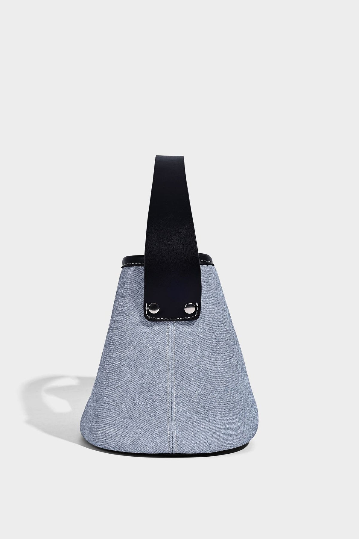 Hellblaue Bucket-Bag aus Denim mit schwarzem Besatz in Lederoptik, silberfarbenen Beschlägen, kurzem Tragegriff und langem verstellbarem Crossbody-Riemen