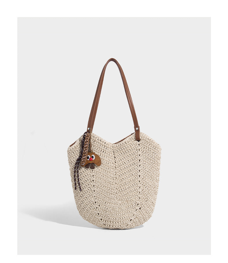Woven crochet open-top shoulder tote bag with slim brown leather-look straps and braided charm accent, detail view 10