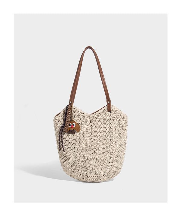 Woven crochet open-top shoulder tote bag with slim brown leather-look straps and braided charm accent, detail view 10