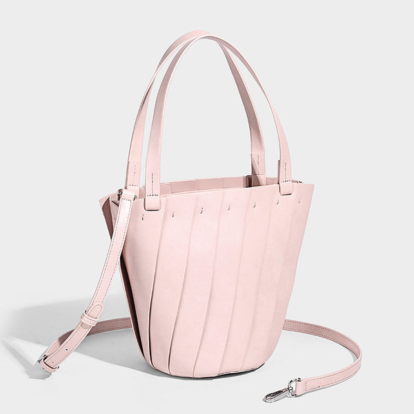 Structured bucket tote bag with vertical panel exterior, dual top handles, and detachable shoulder strap in tan leather-look