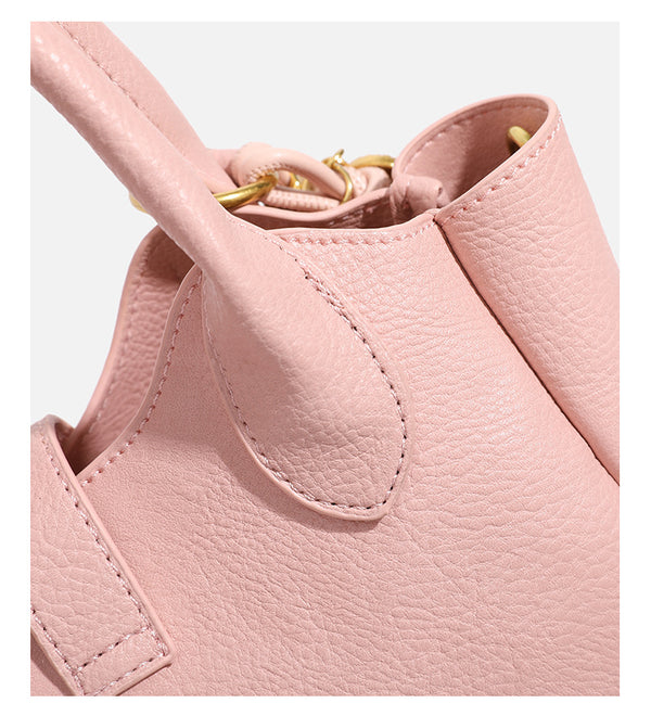 Small structured pebbled leather-look mini tote bag with gold-tone hardware, front toggle closure, knotted bear tassel charm