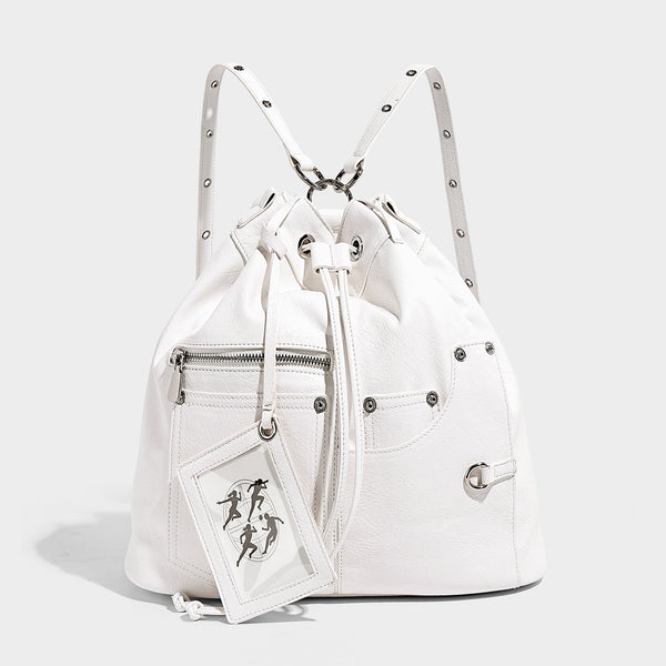 Glossy black convertible bucket backpack with silver grommet-studded straps, drawstring cinch closure, and front zip pocket