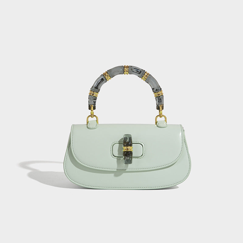 Kleine strukturierte Satteltasche mit durchscheinendem rosafarbenem Henkel aus Kunstharz im Bambus-Stil, passendem vorderem Drehverschluss, goldfarben