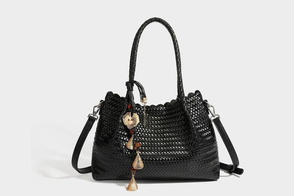 Strukturierter, glänzend geflochtener Shopper mit Muschelkantenabschluss am oberen Rand, geflochtenen Tragegriffen, abnehmbarem Crossbody-Riemen und Perlenquaste
