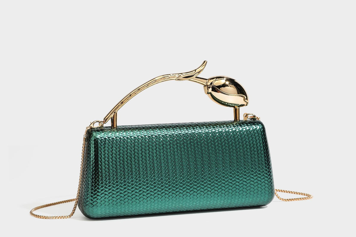 Structured rectangular metallic woven clutch bag with sculptural gold-tone leaf top handle and detachable chain strap, detail