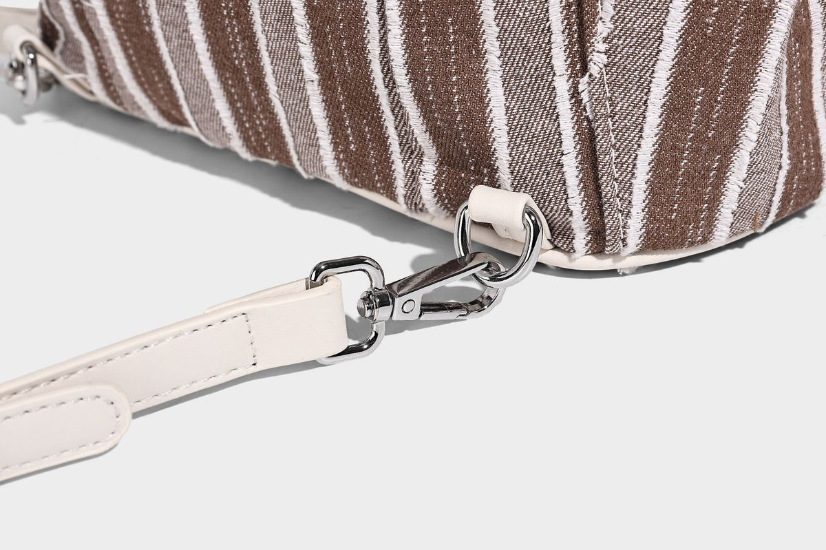 Weicher Rucksack aus gewebtem Material mit vertikalen Streifen, Überschlag, Kordelzug, vorderer Reißverschlusstasche, weißen Besätzen und Trägern in Lederoptik, Detailansicht