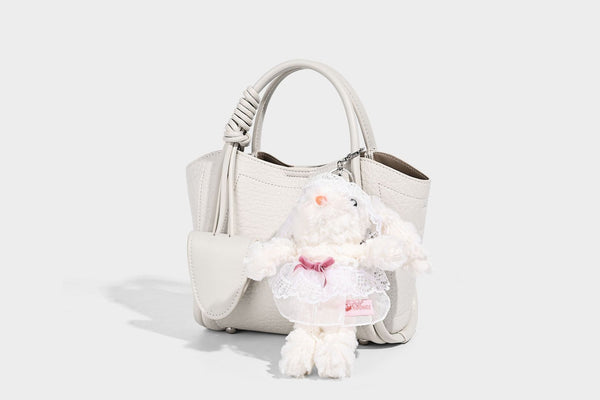 Structured mini tote bag in pebbled leather-look finish with knotted top handles, front flap pocket, and detachable shoulder
