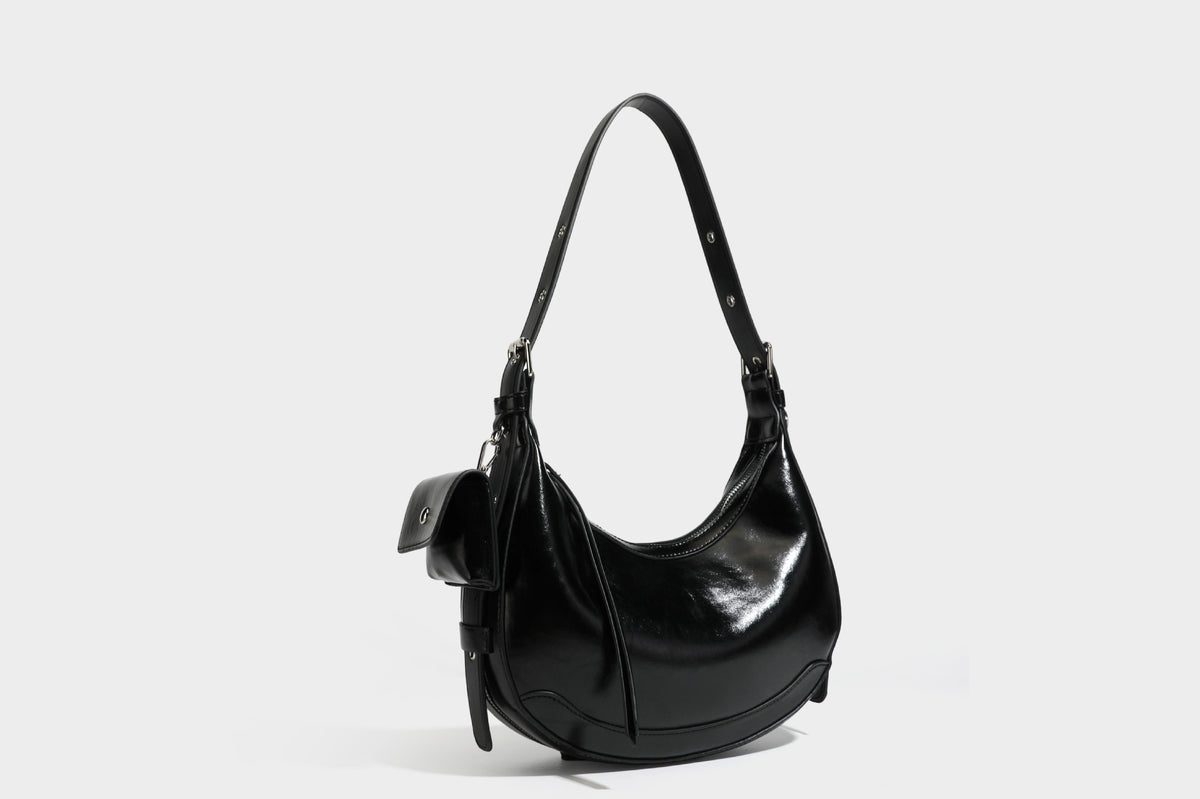 Glossy leather-look crescent hobo shoulder bag with dark contrast trim, silver-tone hardware, and attached mini flap pouch