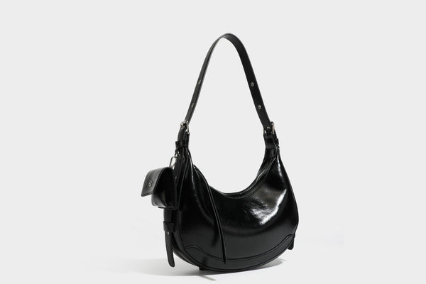 Glossy leather-look crescent hobo shoulder bag with dark contrast trim, silver-tone hardware, and attached mini flap pouch