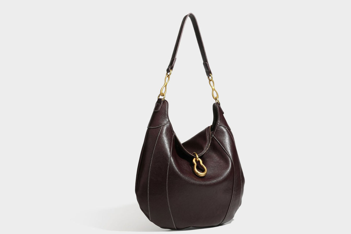 Lässige halbmondförmige Hobo-Schultertasche in Dunkelbraun mit goldfarbenem Ring und Kettenglied-Beschlägen sowie Reißverschluss oben, Detailansicht