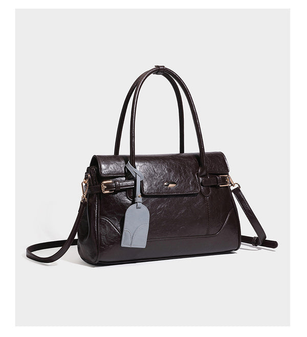 Structured glossy leather-look satchel bag with flap closure, gold-tone buckle accents, double top handles, detachable