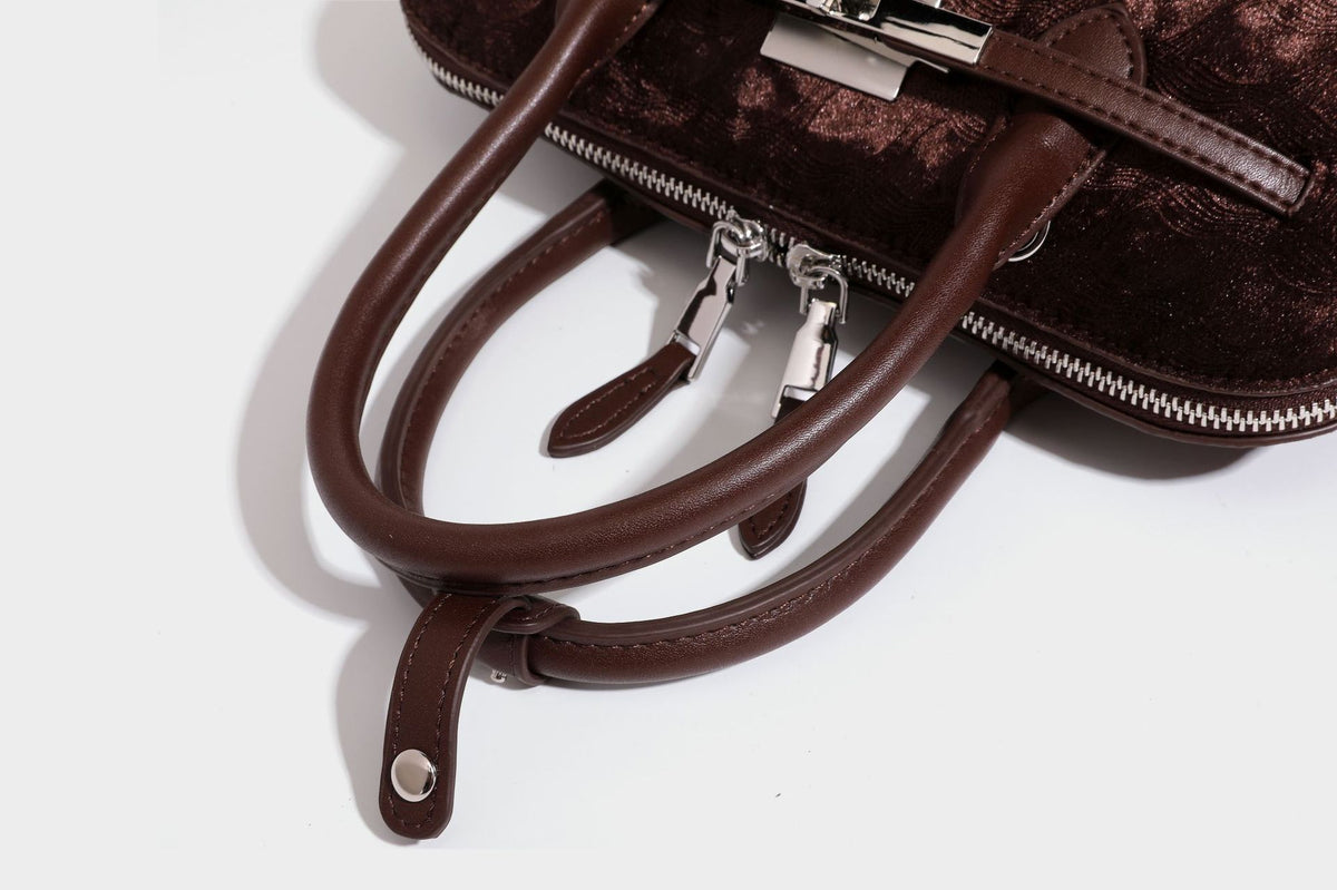 Small structured satchel bag in dark brown velvet-like textured finish with leather-look trim, silver-tone turn-lock bar