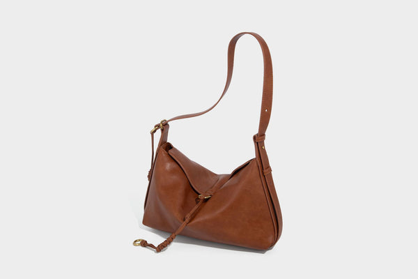 Slouchy brown leather-look shoulder bag with knotted drawcord tie closure, gold-tone ring hardware, and long adjustable