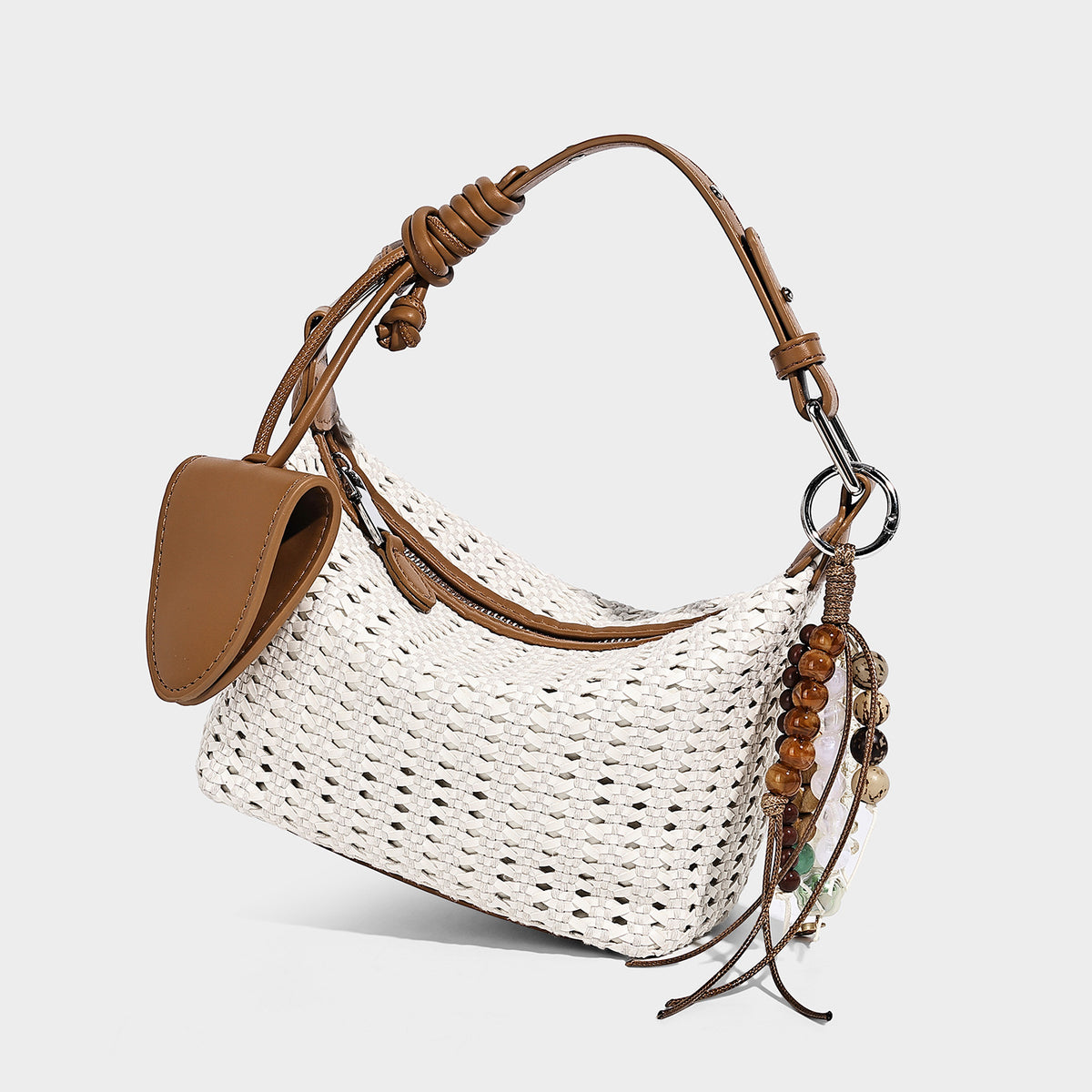 Woven crescent shoulder bag with leather-look knotted handle, zip top, attached mini pouch, and silver-tone hardware, detail