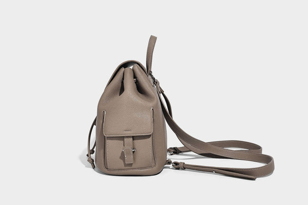 Compact pebbled leather-look flap drawstring backpack handbag with side pockets, top handle, and silver-tone hardware, detail