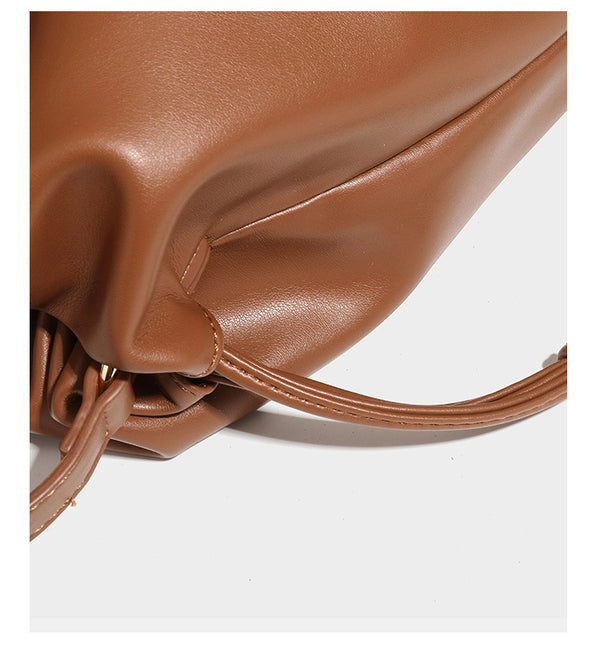 Slouchy ruched drawstring shoulder bag in smooth leather-look finish with gold-tone emblem and slim adjustable strap, detail