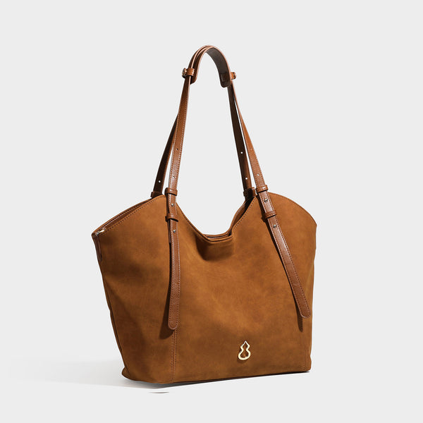 Oversized suede-finish tote shoulder bag in caramel brown with slim leather-look straps and gold-tone logo hardware, front