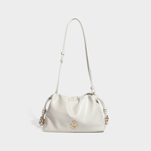 Slouchy ruched drawstring shoulder bag in smooth leather-look finish with gold-tone emblem and slim adjustable strap, detail