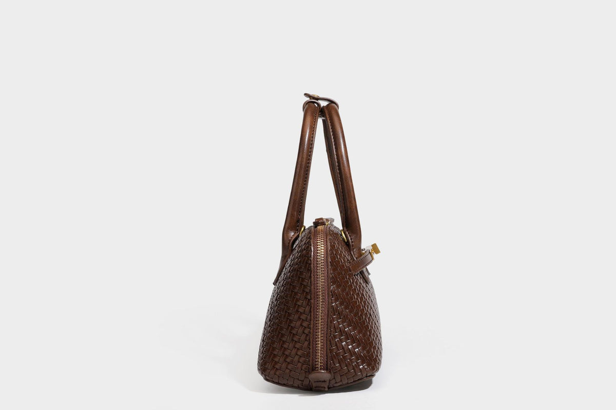 Structured woven-embossed leather-look satchel with dual rolled top handles, gold-tone turn-lock closure, and detachable
