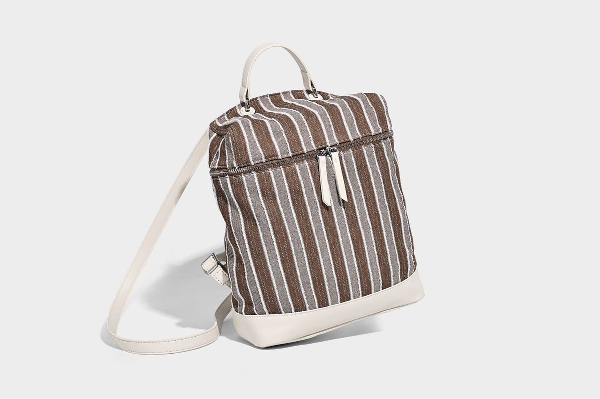 Small structured striped fabric backpack handbag with cream leather-look trim, top handle, and silver-tone hardware, detail