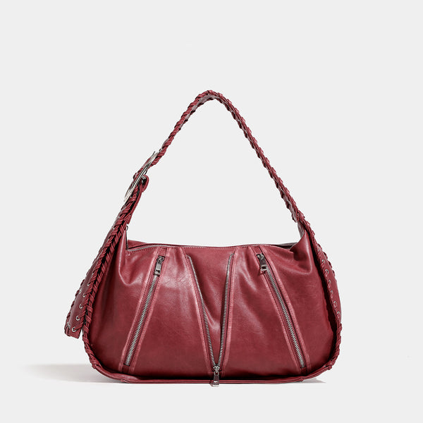 Slouchy hobo shoulder bag with wide braided eyelet strap, multiple front zip compartments, and silver-tone ring buckle, front