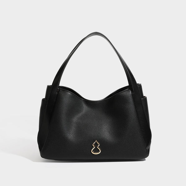 Schwarze Tote-Bag in genarbter Lederoptik mit kürbisförmigen Beschlägen in Goldoptik, zwei Tragegriffen und abnehmbarem Crossbody-Schulterriemen, Detailansicht