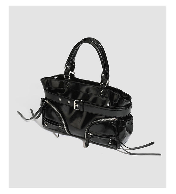 Black glossy structured tote bag with rivet and buckle detail, dual top handles, and detachable shoulder strap, detail view 7