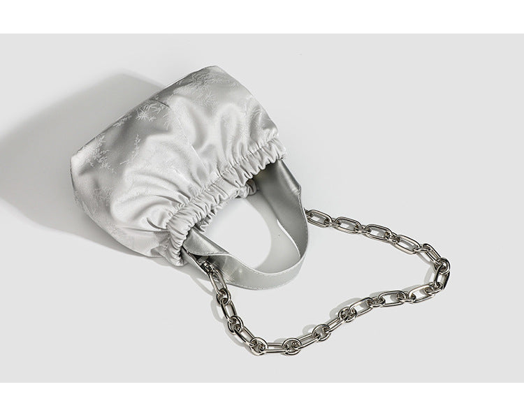Small ruched satin-finish cloud bag with elasticized drawstring top, short top handle, and chunky silver-tone chain strap