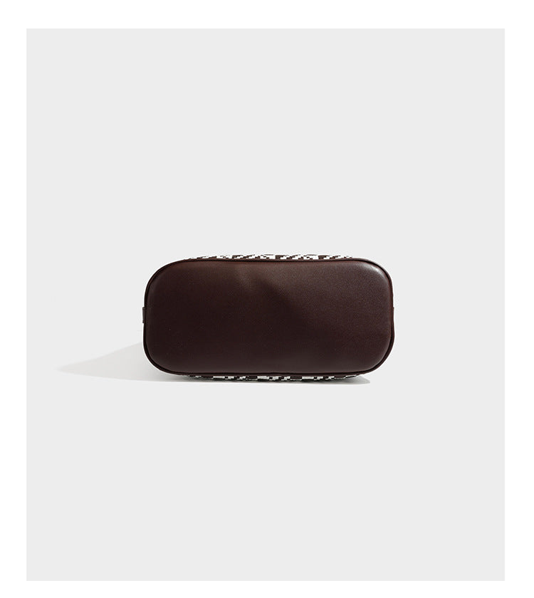 Woven geometric bucket shoulder bag in white and dark brown two-tone pattern with leather-look trim and drawstring top