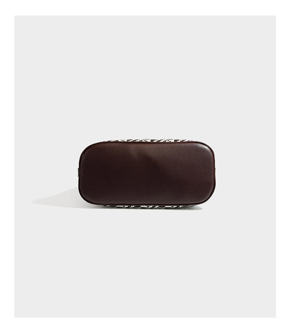 Woven geometric bucket shoulder bag in white and dark brown two-tone pattern with leather-look trim and drawstring top