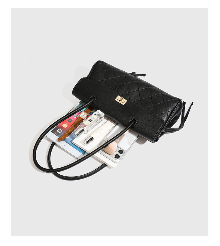 Structured black diamond-quilted shoulder bag with gold-tone turn-lock flap closure and dual round shoulder straps, detail