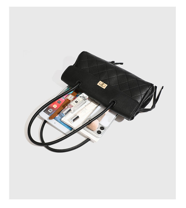 Structured black diamond-quilted shoulder bag with gold-tone turn-lock flap closure and dual round shoulder straps, detail