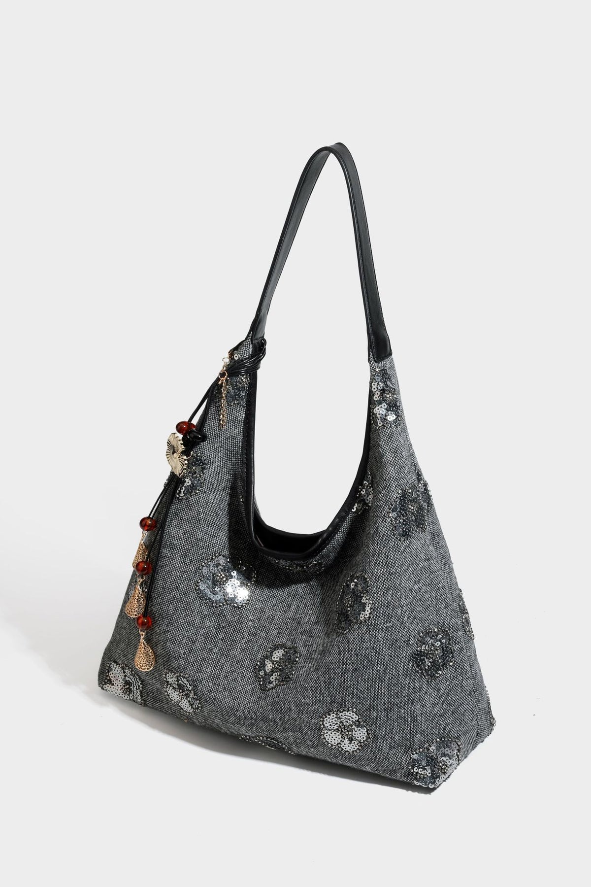 Lässig fallende, trapezförmige Schulter-Tote in Anthrazitgrau mit floralen Paillettenmotiven in Silber, Riemen in Lederoptik und herabhängendem Perlenbesatz