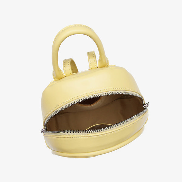 Kleine kuppelförmige Mini-Rucksackhandtasche in Pastellgelb mit glatter Oberfläche in Lederoptik, bogenförmigem Reißverschluss oben und silberfarbenen Details