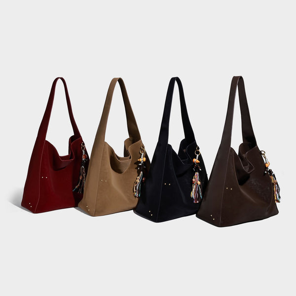Oversized trapezoid tote bag with matte leather-look finish, gold-tone rivets, and long shoulder strap, detail view 2